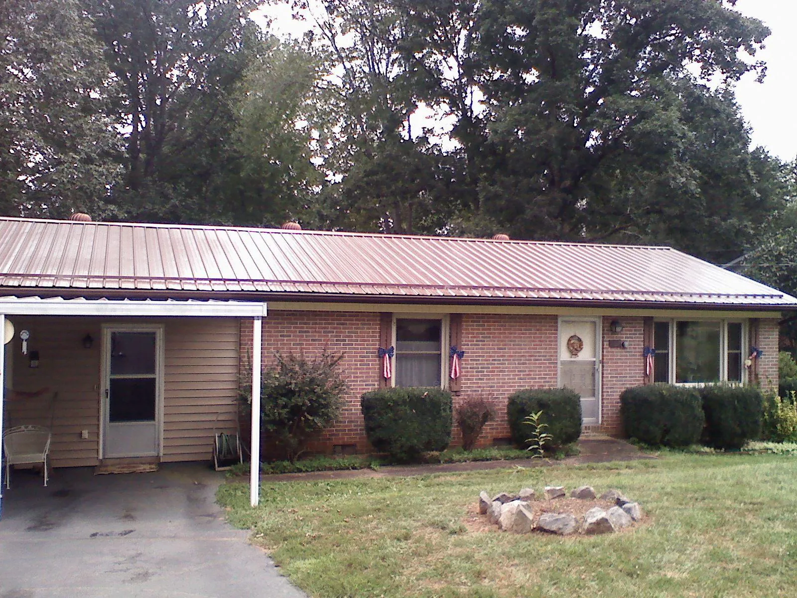 Bronze metal roof and carport on a brick ranch home — Roof Repair work by our crew in New Castle